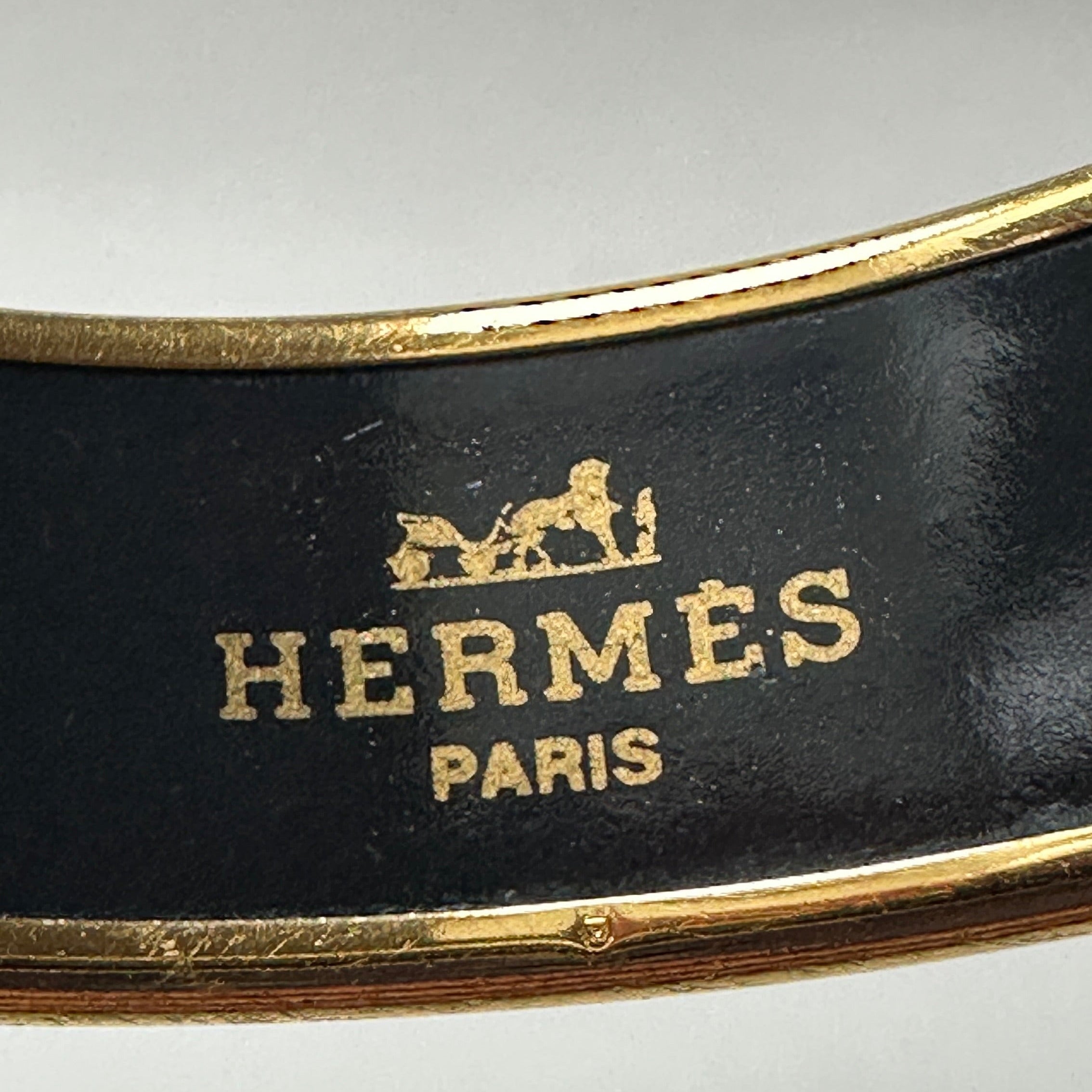 Logo Hermès Paris doré imprimé à l'intérieur de la manchette avec poinçon en émail noir.