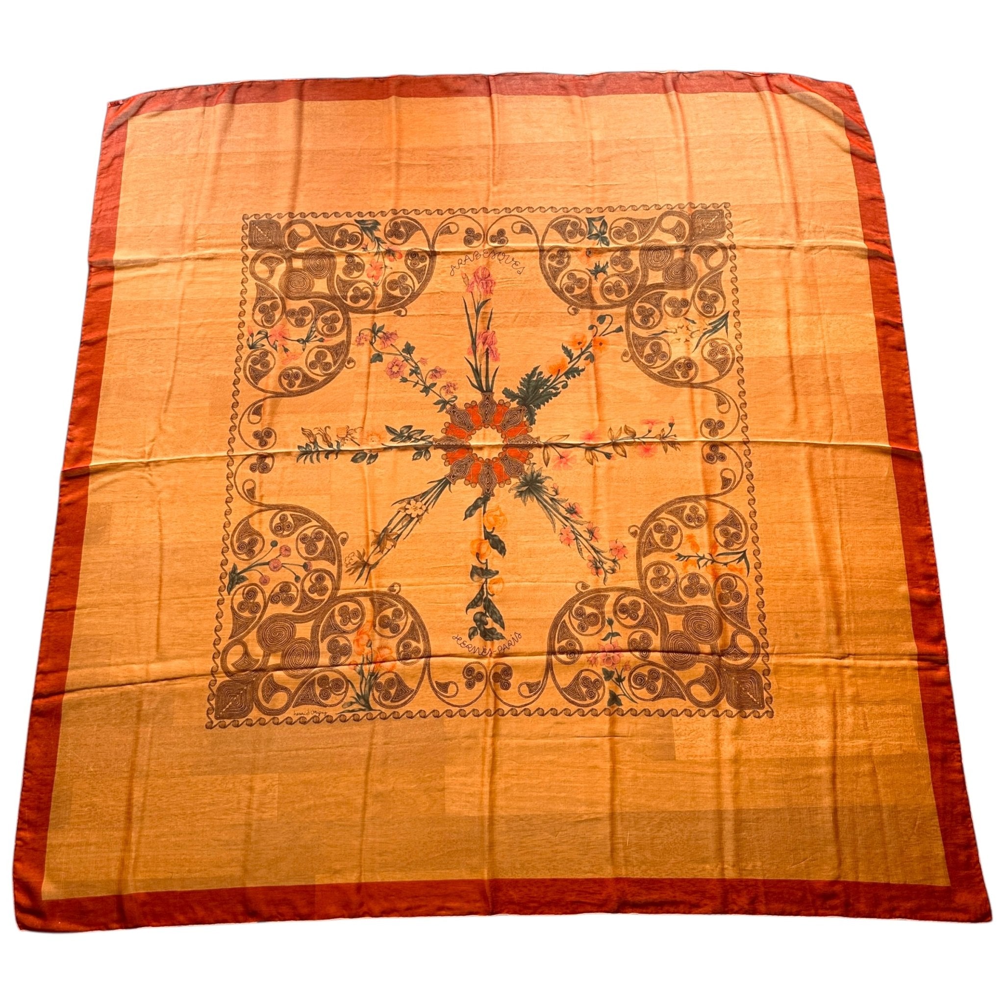 Vue générale du carré géant Hermès "Arabesques" 140 cm en mousseline, motif ornemental rouge et or.