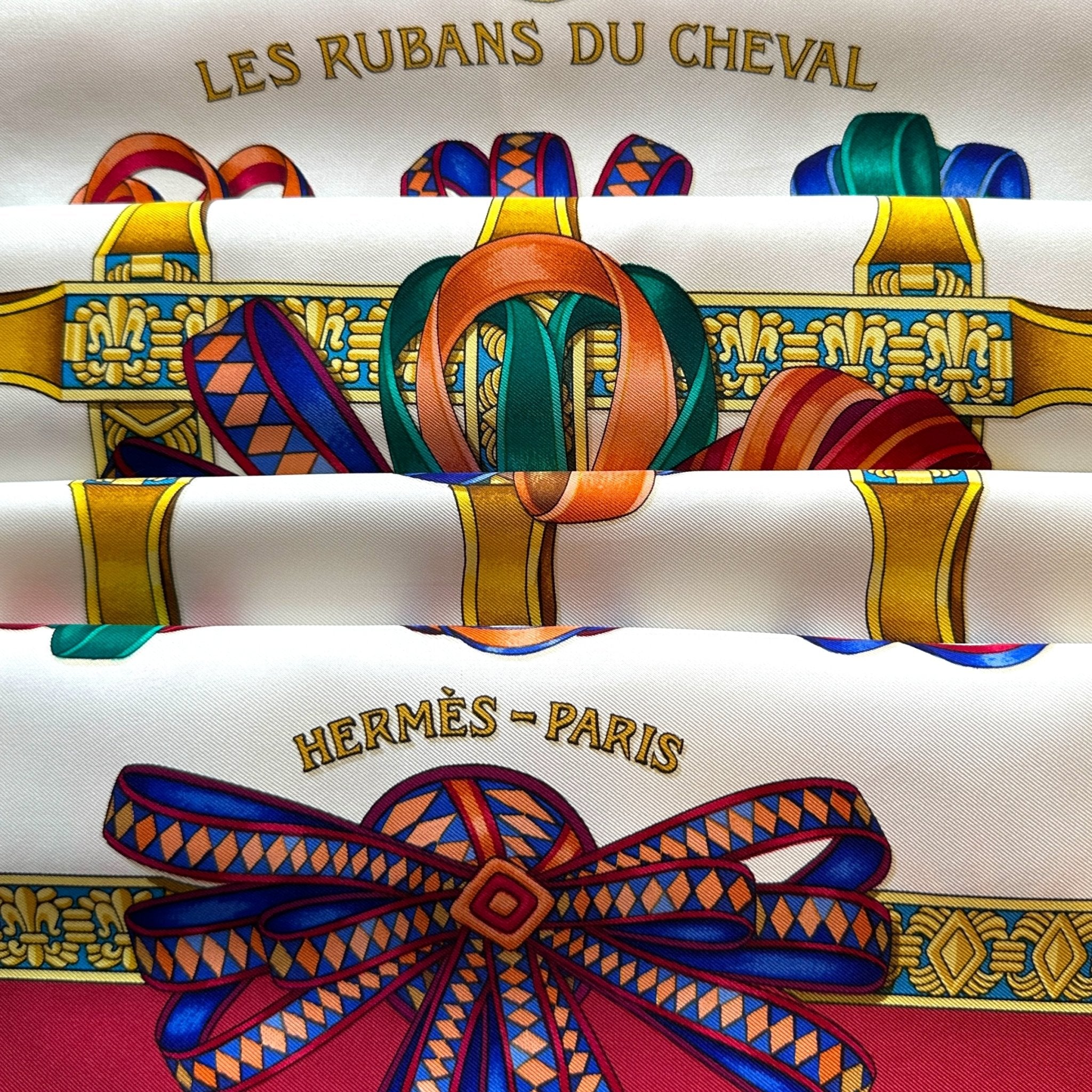 Foulard Hermès Les rubans du cheval 90 cm – Vue d’ensemble, fond blanc, bord rouge grenat