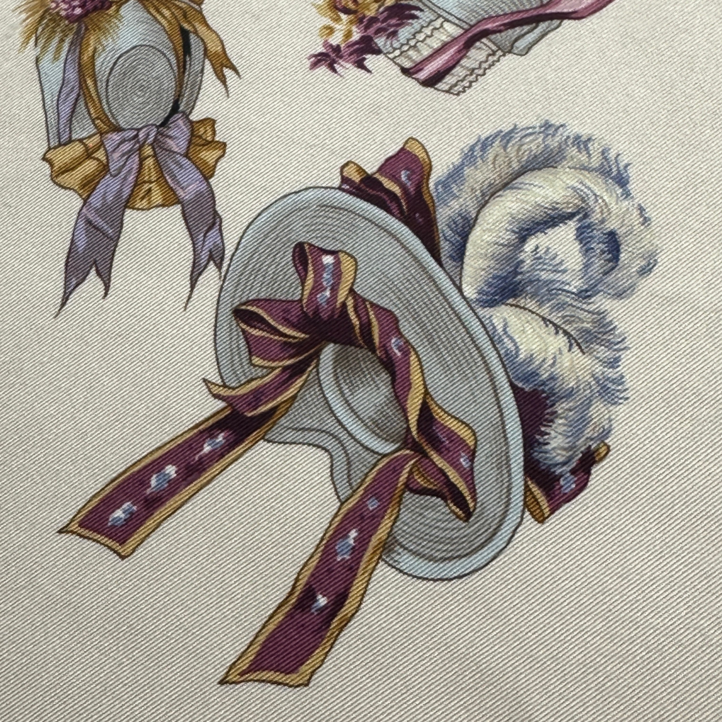 Zoom macro sur la texture du twill de soie et la précision du dessin d'un chapeau blanc orné de rubans violets.