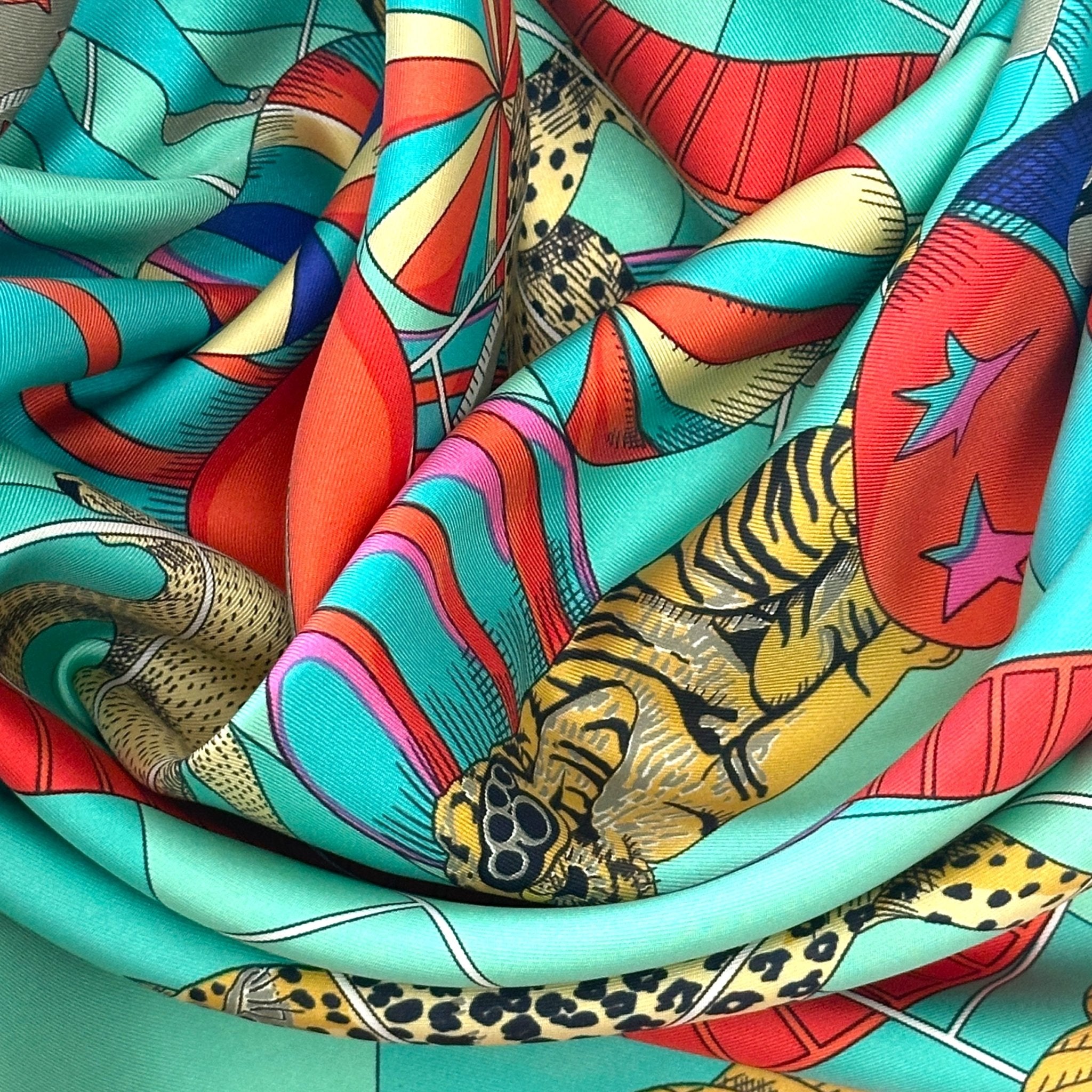 foulard hermes d'occasion circus entourage couleur corail et turquoise par annie faivre en bon etat 